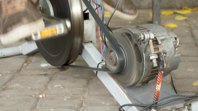 Student pedals bicycle and generates electrical energy. Engineering, science, technology for DIY innovation