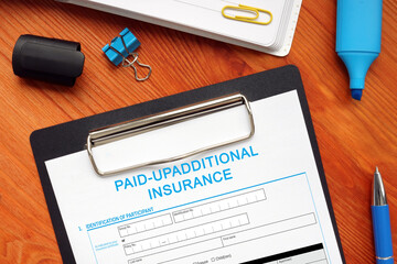 Financial concept about PAID-UPADDITIONAL INSURANCE with inscription on the business paper