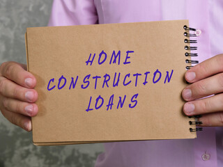 Financial concept meaning HOME CONSTRUCTION LOANS with inscription on the piece of paper.