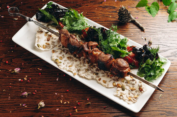 Traditional duck shashlik on a barbecue skewer on white plate