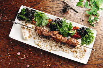 Traditional duck shashlik on a barbecue skewer on white plate