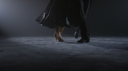 Ballroom dancers feet performing on stage. Dance couple legs training in class.