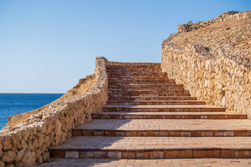 Detail of stairs and stone wall on the beach near sea water of Egypt in Sharm El Sheikh