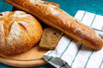 Bakery products. Fresh bread. Round loaf of bread, baguette on a cutting board.