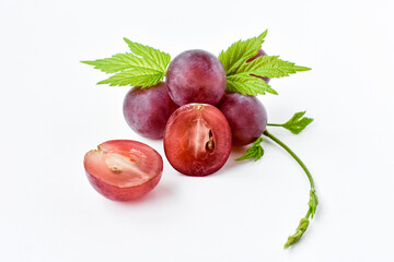 Fresh, juicy berries of red grapes and a green vine on a white background. Close-up of a slice of...