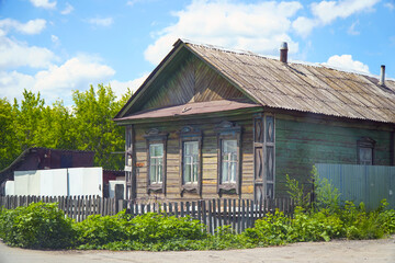 Old abandoned rustic wooden house with three windows on the facade