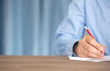 Obraz premium Close-up hand holding pen writing on paper 