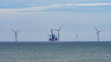 The view from the promenade in Withernsea of the North Sea with wind turbines and an offshore oil rig