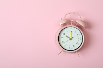 Alarm clock on pink background, space for text