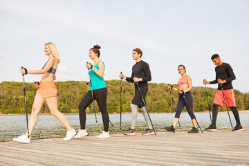 Gruppe junger Leute macht Nordic Walking