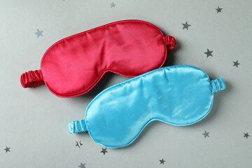 Sleep masks on gray background, close up
