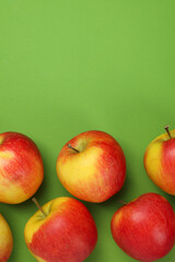 Ripe apples on green background, space for text