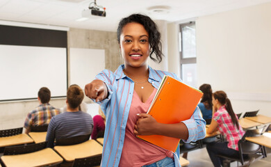 education, school and people concept - happy african american young student woman with notebooks...
