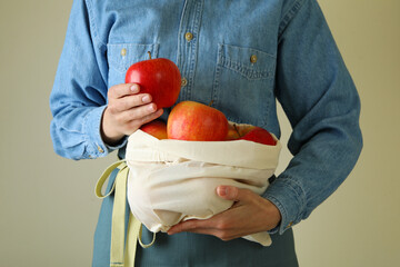 Woman holds bag with ripe red apples