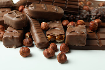 Different tasty candy bars on white background