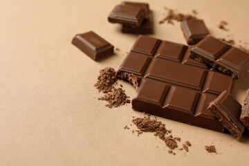 Tasty chocolate bar and powder on beige background