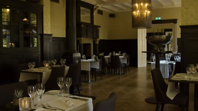 wide Dolly in of empty dining room in luxurious restaurant