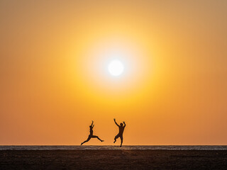 silhouette of a person jumping on the beach