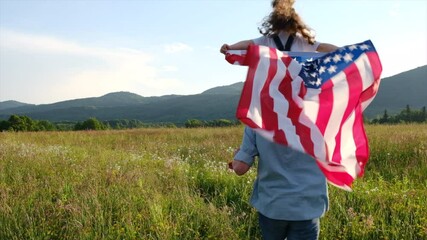 Back view of young father holds cute little daughter on shoulders with USA flag, enjoying walking on nature, free proud independent patriotic family feeling freedom, independence concept. Slow-motion