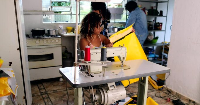 Entrepreneur black woman working from home knitting on machine