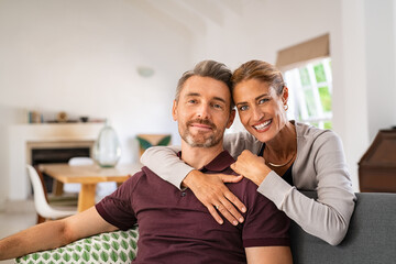 Mature woman hugging man from behind at home