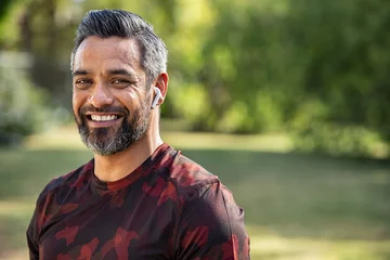 Tuinposter Mid adult indian man smiling after running © Rido