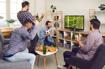A group of young comrades watch a football game at home on TV, celebrating a goal-scoring beer and pizza. Happy friends watching soccer match, hanging out together concept