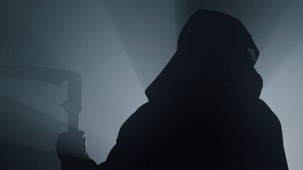 Silhouette of grim reaper indoors. Scytheman standing in darkness.