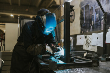 Manual worker welder on his job. People at heavy industry work.