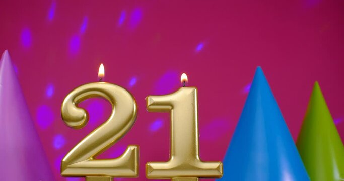 Burning birthday cake candle number 21. Happy Birthday background anniversary celebration concept. Birthday hat in the background