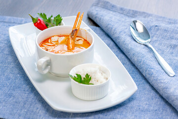 Tom yam shrimp soup beautifully served in a white bowl in the restaurant. Restaurant menu concept