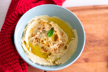 Hummus in bowl on rustic wood