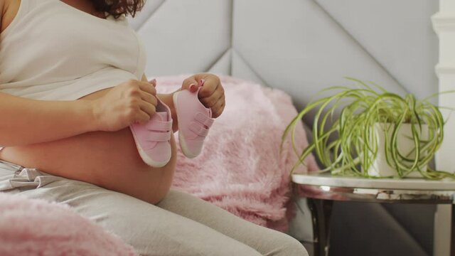 Pregnant woman expecting twins. Pregnant woman feeling happy at home while taking care of her child. Woman pregnancy concept and maternity prenatal care. Young expecting mother  Slow motion.