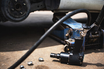 The hydraulic  jack is installed under the car and lifting it.