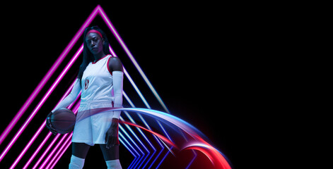 Beautiful african-american female basketball player in neon light on blue background. Concept of...