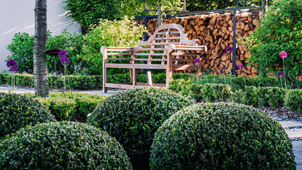 Ogród nowoczesny z ławeczką i   bukszpanem