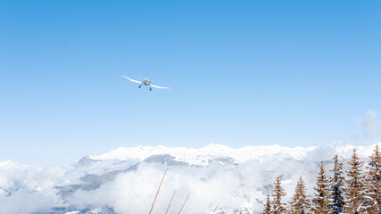 Fototapeta na wymiar Propeller airplane in mountainous winter landscape 