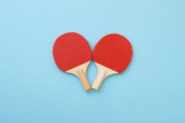Crossed red ping pong rackets, wooden rackets