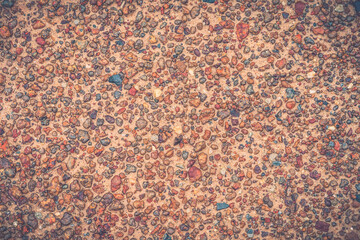 Ground and stone background. Small reddish-brown stone.