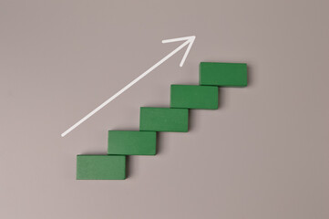 Wooden blocks with arrow pointing upward. Business start up and economic growth concept.