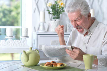 Fototapeta premium Senior man reading newspaper