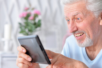  senior man using tablet at home