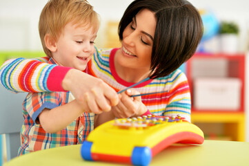 Young mother and cute little son playing