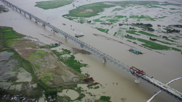 Aerial view of a building site while assembling the Padma bridge, the longest rail and highway bridge in Bangladesh crossing the Padma river, Zajira, Dhaka, Bangladesh.