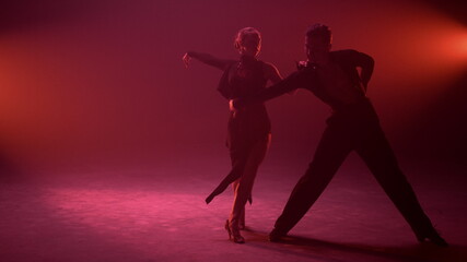 Passionate couple bending during dance indoors. Ballroom partners dancing