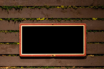 Mock-up horizontal frame made of rough wood painted in black on rustic wooden background