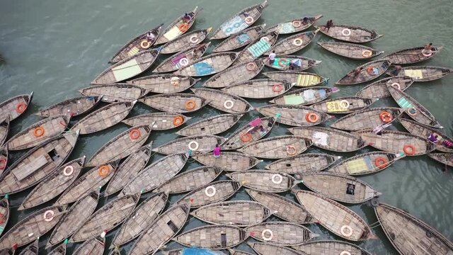Aerial view of traditional fishing boat among docked ferry boat along Buriganga river in Keraniganj, Dhaka state, Bangladesh.