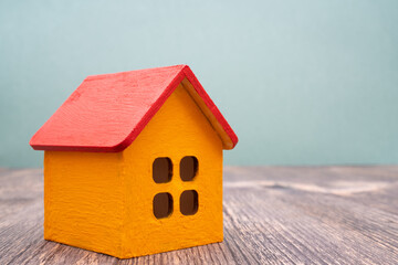 Model of a wooden yellow house with a red roof. Rent and sale of buildings and cottages.