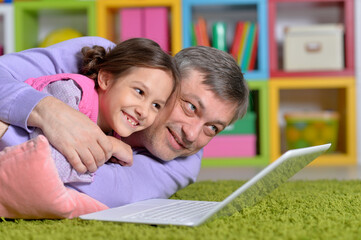 Father with little daughter using laptop