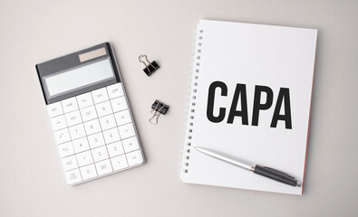 The word capa is written on a white background next to a pen ,calculator and reports. Business concept